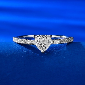 Close-up of heart-shaped sparkling gemstone ring on blue velvet display base