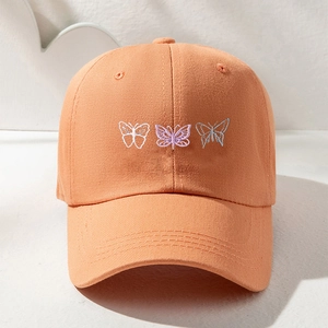 Bright apricot cotton baseball cap with artistic butterfly embroidery on a clean background