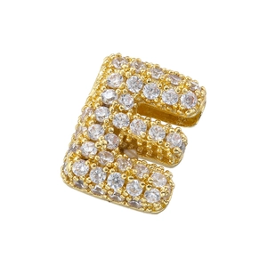 Macro shot of gold-plated letter E pendant encrusted with clear cubic zirconia stones