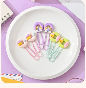 Close-up of colorful macaron paper clips with cute donut resin charms on a white plate