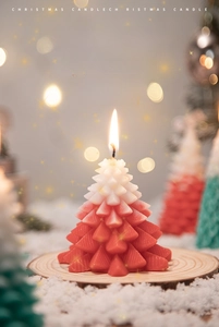 Detail of red and white gradient Christmas tree candle with realistic needle textures