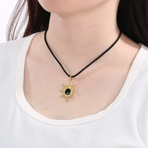 Golden eight-pointed star necklace with black gem and pavé diamonds on a black cord