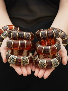 Detailed close-up of leopard print resin bangles with golden metal divider accents