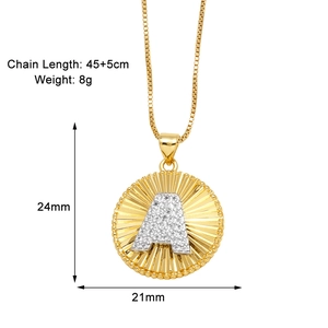 Detailed macro view of gold-plated sunburst disc pendant with letter A and cubic zirconia