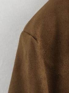 Gros plan sur la texture en daim marron et les coutures de ce blazer mode pour femme