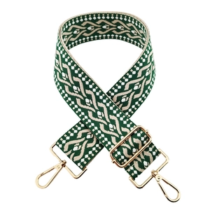 Detail of 5cm wide green and beige woven guitar strap with gold metal swivel hooks