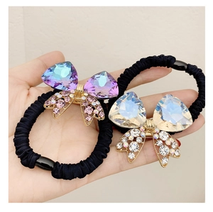 Detail of high-elastic black hair ties with luxury crystal bow pendants and rhinestones