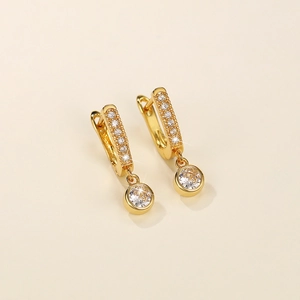 Detail view of gold-plated hoop earrings with micro-pave cubic zirconia and round pendant