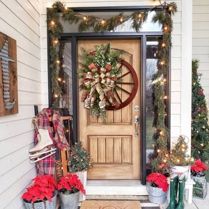 Rustic Christmas wooden wheel wreath with pine needles, red berries and a large plaid bow
