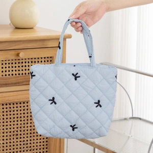 Close-up of a blue quilted floral tote bag featuring cute black rabbit embroidery