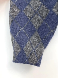 Close-up of diamond pattern knit cuff showing blue and dark grey texture on the jacket