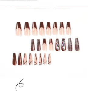 Detailed view of long coffin press-on nails with brown marble patterns and rhinestones