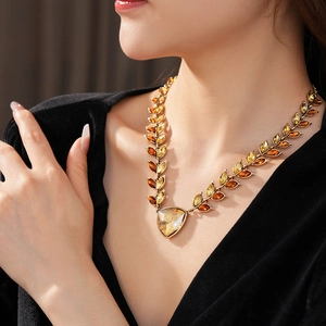 Détail d'un collier vintage doré à motif épi avec gemmes ambre sur un mannequin