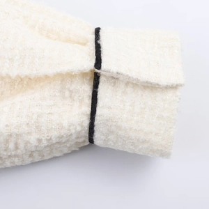 Detailansicht der weißen Tweedjacke mit schwarzen Kontrastkanten und Texturstoff