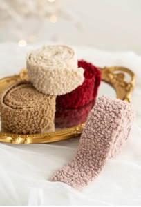 Detail of wool felt ribbons in cream and crimson on a vintage golden carved tray