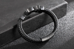 Close-up of braided black leather bracelet with matte black textured metal buckle