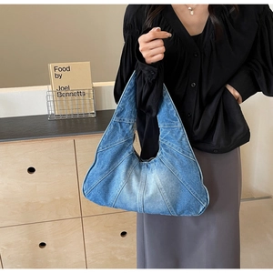 Gros plan détaillé des empiècements en jean patchwork sur un sac à bandoulière bleu