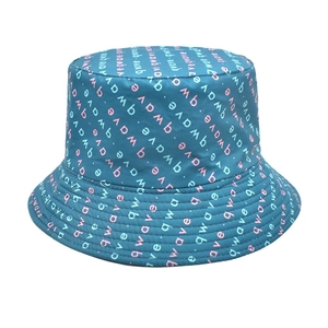Detail of teal reversible bucket hat with all-over pastel qwave letter print
