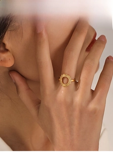 Detailed close-up of golden sunflower ring with hollow circular design and sunburst texture