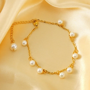 Detail of 18K gold-plated stainless steel anklet with pearls on silk background