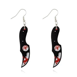 Macro detail of acrylic Halloween karambit knife earrings with realistic red blood splatter