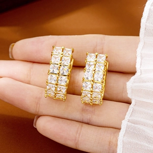 Luxurious gold geometric hoop earrings with double-row diamond inlay held by hand