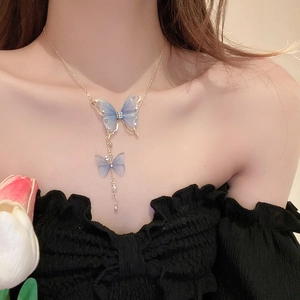 Detail of blue tulle butterfly pendant necklace with crystal accents on a model