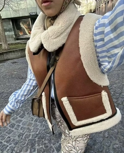 Détail d'un gilet vintage en peau de mouton beige et marron avec fermeture éclair et poches