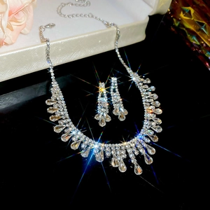 Detailed view of silver water drop tassel necklace and earrings with sparkling rhinestones