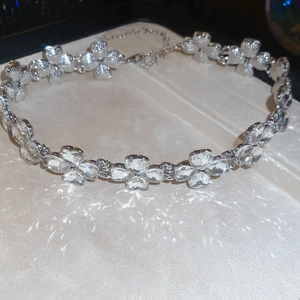 Detail view of silver clover necklace with clear faceted crystals and adjustable chain link
