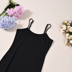 Abito nero attillato a bretelle su sfondo beige con eleganti accenti floreali