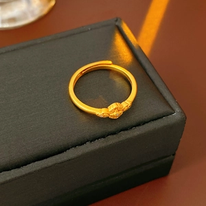 Dettaglio macro dell'anello vintage dorato a fiore con zirconi su scatola nera