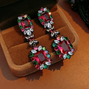 Detailed macro view of vintage baroque drop earrings with colorful zircon in a velvet box