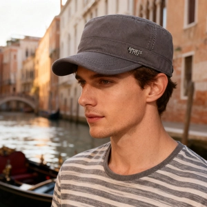Dark grey cotton flat top army cap with metal sports style logo worn outdoors