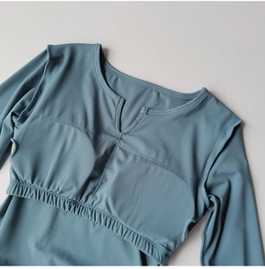 Détail du haut de sport bleu brume avec col en V et ourlet de taille élastique large