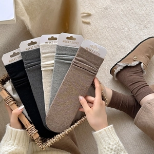 Detailed view of five multi-color combed cotton crew socks arranged in a woven basket