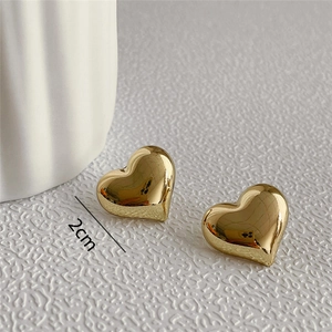 Macro view of 2cm polished gold heart stud earrings with mirror finish and sizing details