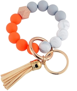 Detail of beaded keychain with orange silicone beads, wood hex bead and beige tassel