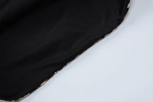 Gros plan détaillé du tissu en maille noire avec bordure élégante en paillettes dorées