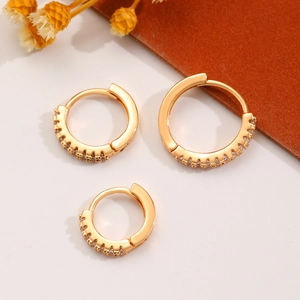 Detailed view of three gold-plated hoop earrings with cubic zirconia in various sizes