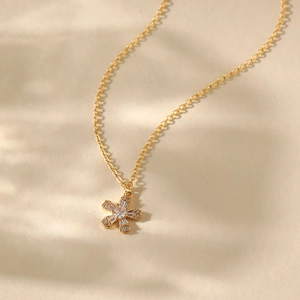 Macro shot of 18K gold plated fan-shaped floral pendant necklace with sparkling zircons
