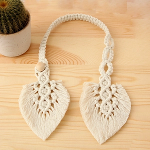 Close-up of handmade cream cotton leaf woven curtain tieback with decorative wood bead