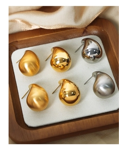 Macro shot of 18K gold plated teardrop stud earrings in glossy and matte finishes