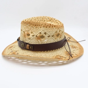 Detail of hollow woven straw cowboy hat featuring leather band and metal bull head