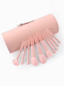 Close-up of peach pink makeup brushes set with a matching leather texture storage tube