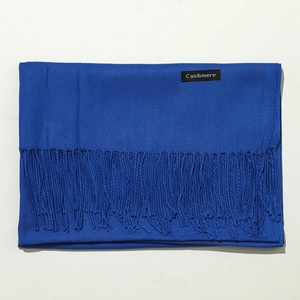 Close-up of blue cashmere scarf with tassels showing material quality and texture