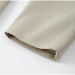 Close-up of beige blazer sleeve with twill fabric texture and professional stitching