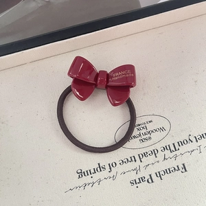 Detailed view of handmade wine red acetate bow hair tie with gold France lettering