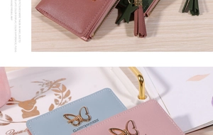 Detailed macro view of short PU leather wallets with butterfly buckles and tassel zippers