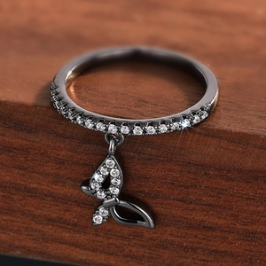 Close-up of butterfly pendant ring with sparkling crystals on dark wood background